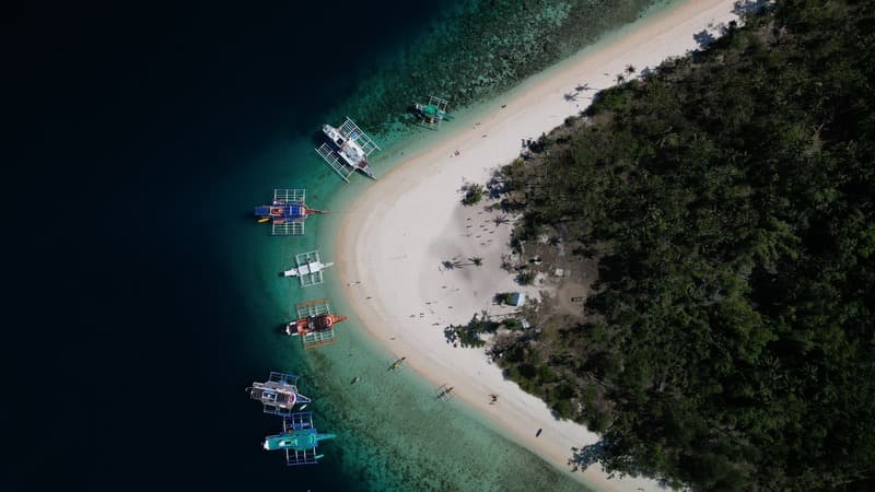 Plage de sable blanc et bateaux vus du ciel