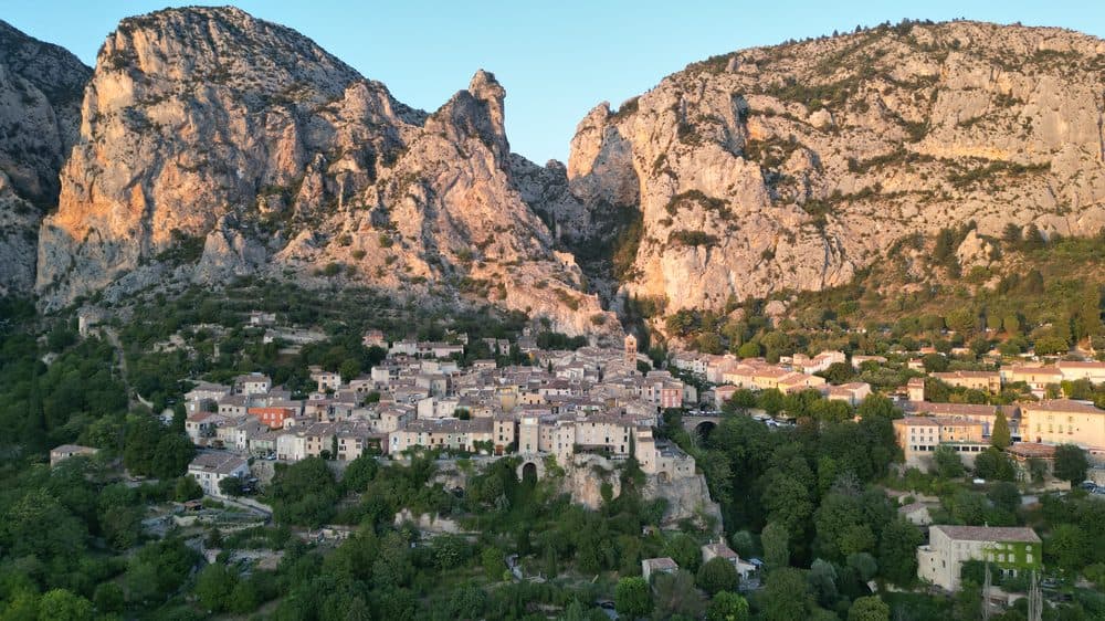 Village perché au pied de falaises, vu du ciel